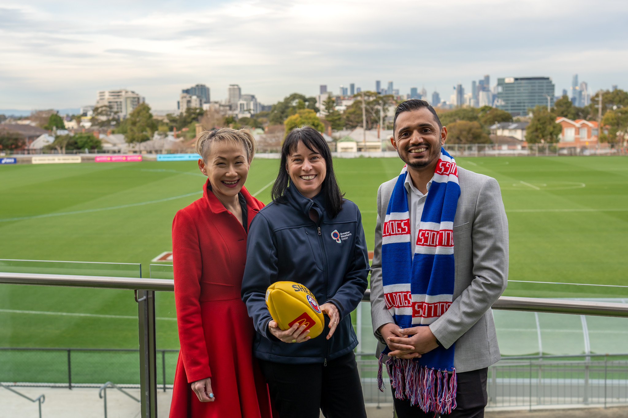 Three officials pose with a football.