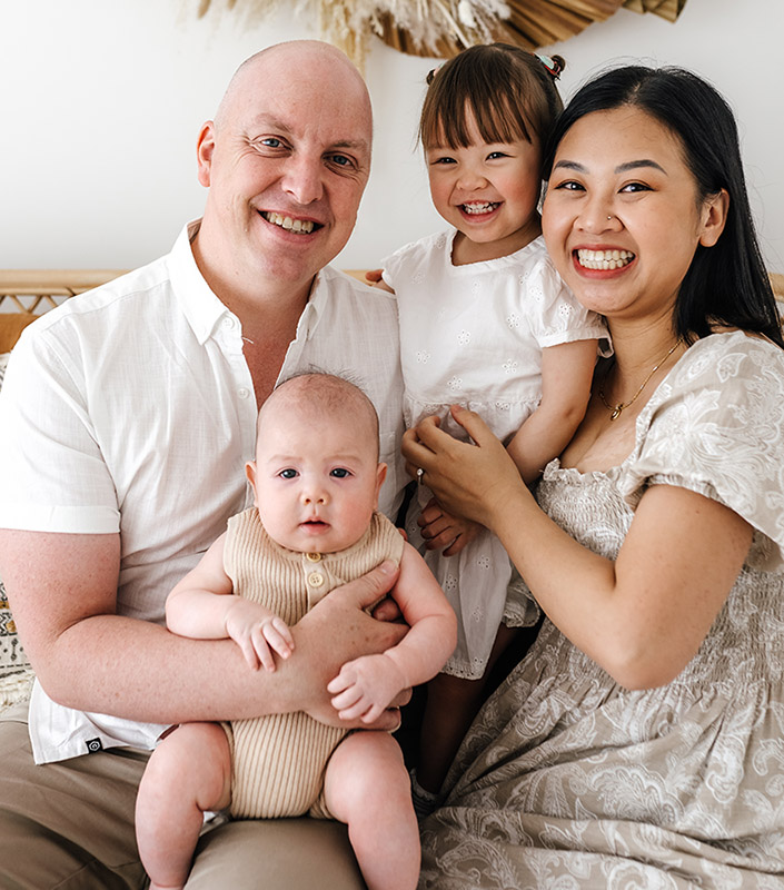 A family photograph, parents and children cuddling and smiling.