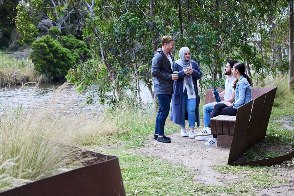 A group of four people talking in a park.