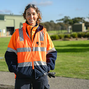 Hannah is standing wearing a GWW branded hi-viz jacket.