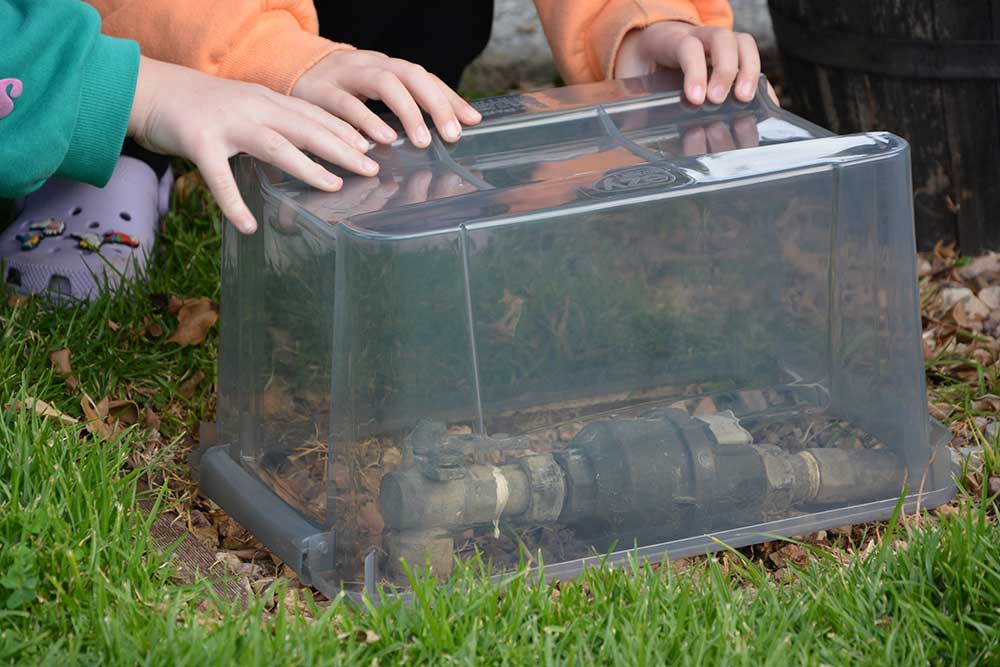 A clear plastic container is placed over the water meter to help prevent it from freezing during cold weather.