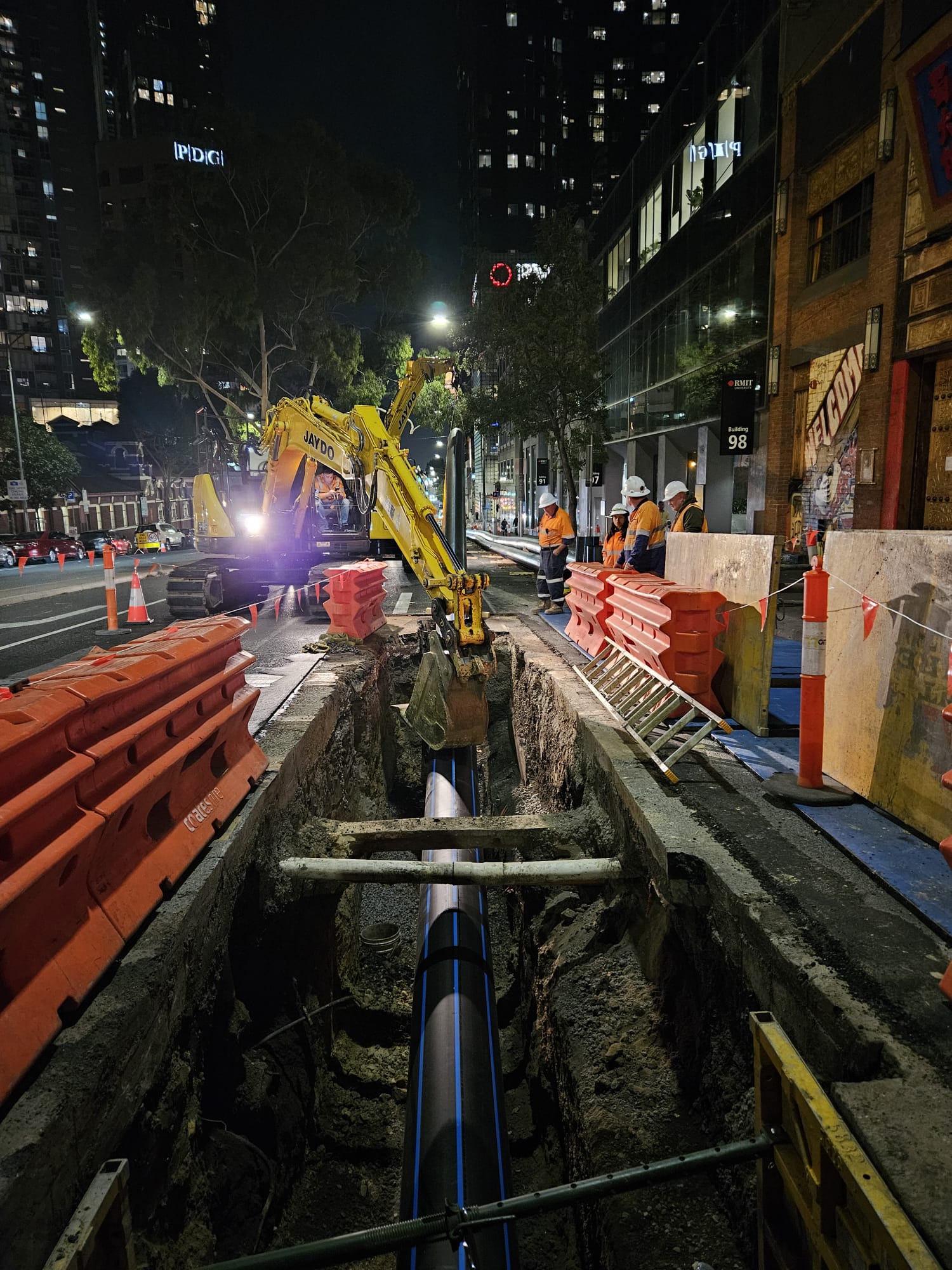 A new water pipe is installed in a bust street at night. 