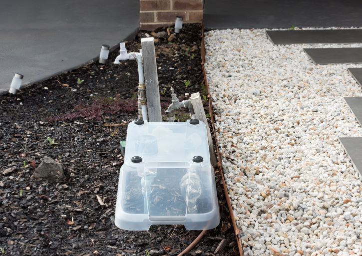 Image shows a plastic container covering the water meter to protect it from freezing.